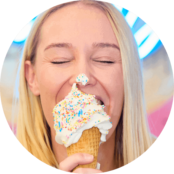 Lady eating an ice cream with some on her nose